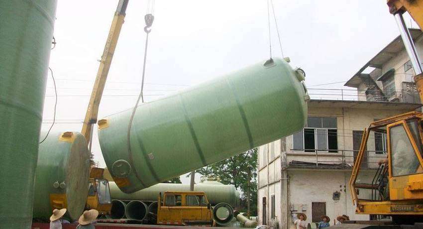 FRP chemical storage vessel is lifted by a crane.