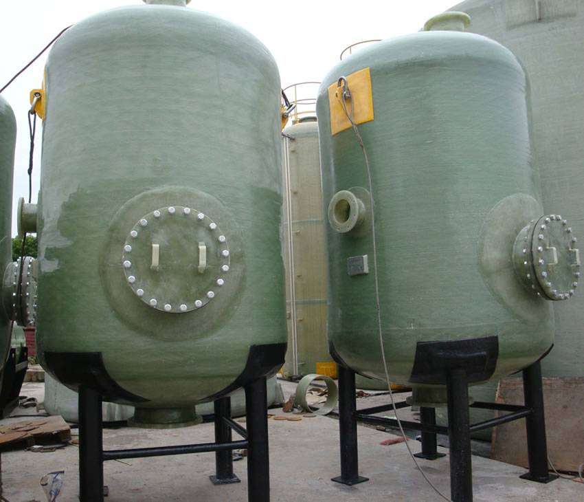 There are two FRP chemical storage vessels with black four-leg supports.