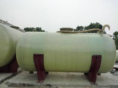 There is a horizontal FRP tank with two red saddle supports.