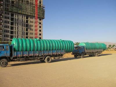 Two threaded FRP septic tanks are delivered to worksite.