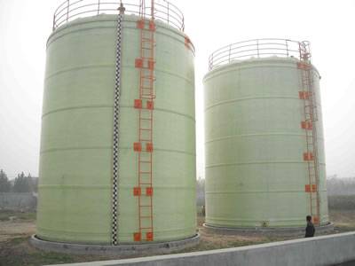 There are two vertical FRP tanks with orange ladders.