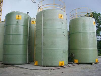 There are several FRP chemical storage tank with yellow ladders.